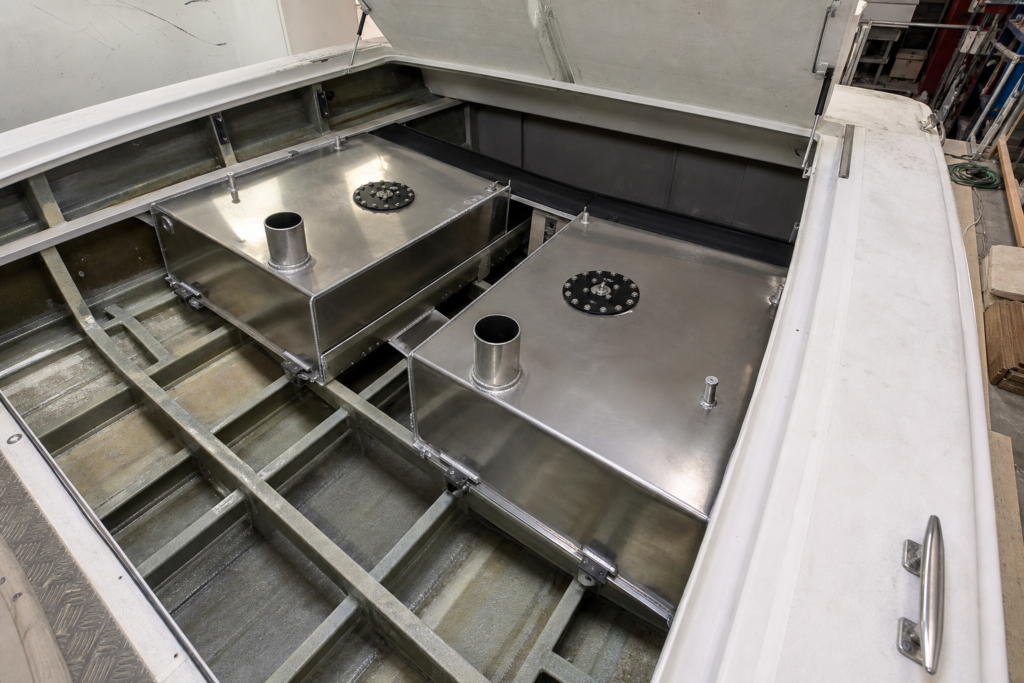 Twin metal fuel tanks installed beneath a powerboat cockpit