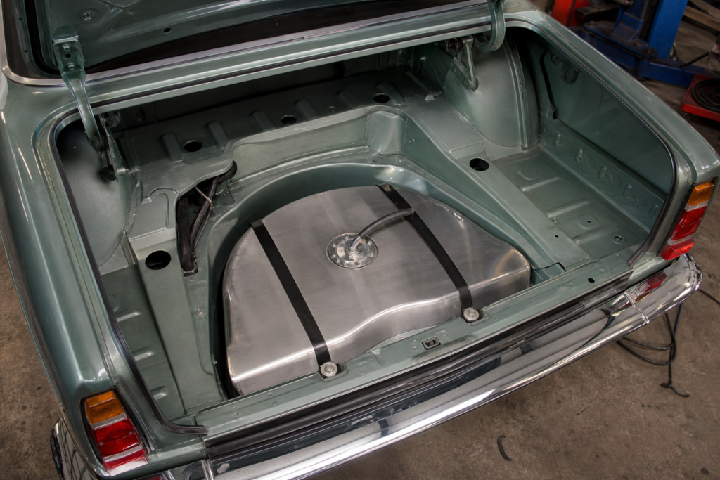 Shaped metal fuel tank installed in a classic sedan boot
